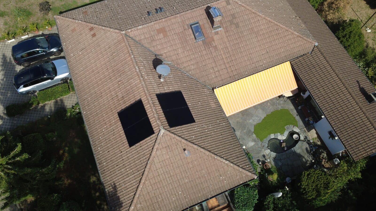 Balkonkraftwerk mit vier Solarmodulen auf einem Walmdach mit Tonziegeln in Klettgau-Erzingen, je zwei nach Osten und Westen, Luftaufnahme